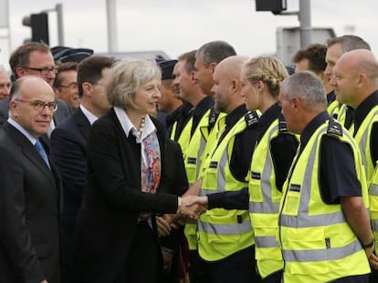 La ministra de Interior británica, Theresa May, saluda a los agentes de policía franceses y británicos durante su visita a las plataformas de embarque del Eurotunnel, el 20 de agosto de 2015.