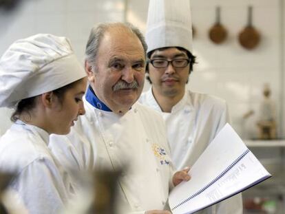 Luis Irizar, en el centro, junto a dos alumnos en su escuela de cocina, en San Sebastián.