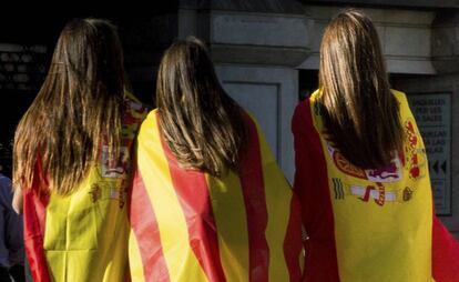 Tres j&oacute;venes con banderas espa&ntilde;olas y catalanas tras la manifestaci&oacute;n celebrada el pasado d&iacute;a 29 en Barcelona. 