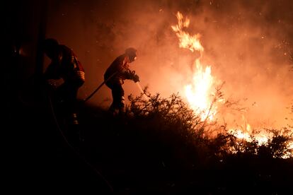 Bomberos en acción mientras un incendio forestal sigue activo cerca del pueblo de Barracao, en el municipio de Leiria, Portugal, este miércoles 13 de julio.