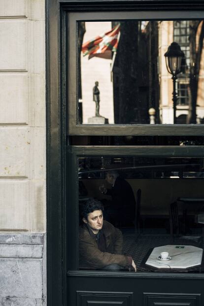 Jon Viar, en el Café Iruña de Bilbao. En la cristalera se refleja la estatua de Sabino Arana, fundador del PNV, y la ikurriña en la sede del partido.