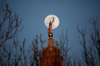 La luna se eleva detrás de la estatua conocida como Miss Penn, ubicada en la cúpula del Capitolio de Washington.