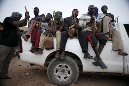 Un grupo de migrantes sentados en la parte trasera de un camión, justo antes de salir de viaje a través del desierto.