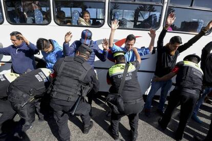 Un grupo de hombres que viajaba en autobús es inspeccionado por la policía.