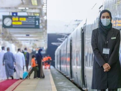 Una empleada de Renfe junto a un tren de la línea Haramain, en Arabia Saudí.