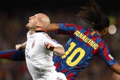 Stam y Ronaldinho saltan intentando alcanzar el balón.
