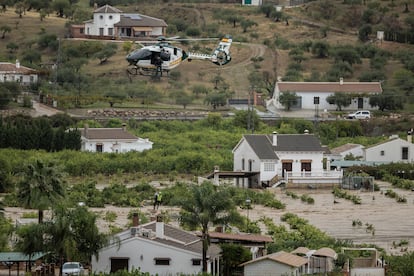 Agentes de la Guardia Civil rescatan con un helicóptero a varios vecinos de la localidad malagueña de Álora tras quedarse incomunicados por el desborde del río Guadalhorce, este martes.