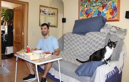 Silvio Serafino (33 años, Napoli) monta una mesa para comer en la sala, porque no hay espacio en la cocina de su casa en San Blas (Madrid). Comparte piso con su pareja y con Steven, su gato.