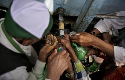 Nueva Delhi, 18 de marzo de 2015: Granjeros indios se afanan en recolectar agua de un grifo durante una protesta frente al Parlamento de su país a causa de un nuevo proyecto de ley para regular la adquisición de tierras. La iniciativa, actualmente en trámites, propone ablandar las leyes para comprar terreno con el fin de facilitar la construcción de infraestructuras.