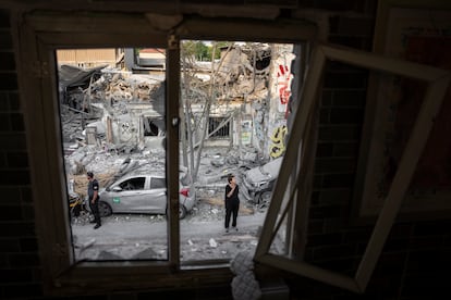 Ciudadanos israelíes inspeccionaban este domingo en Tel Aviv los daños causados en varios edificios por los misiles lanzados desde la franja de Gaza. 