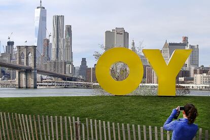 “Oy” es una ruda y antigua interjección judía que se oye con frecuencia en las calles de Nueva York expresando disgusto, cabreo o exasperación. En un atasco, por ejemplo. Esa es la palabra que forman las dos grandes letras amarillas de la foto, una escultura efímera en aluminio de la artista neoyorquina Deborah Kass que se puede ver hasta agosto de 2016 en el parque del puente de Brooklyn. Su significado cambia si se mira desde Manhattan, al otro lado del puente: “Yo” puede ser ser tanto la “forma de nominativo de primera persona singular en masculino y femenino”, según la RAE, si se trata del pronombre personal en español, como una exclamación coloquial en inglés habitual en la costa este de Estados Unidos para dirigirse a alguien y llamar su atención: “Yo, Mike! How’s things?” (algo así como “¡Eh, oye, Mike! ¿Cómo te va?”). Según su autora, la obra, titulada Oy / Yo, es “un monumento a la belleza de las palabras y la diversidad de Nueva York”.