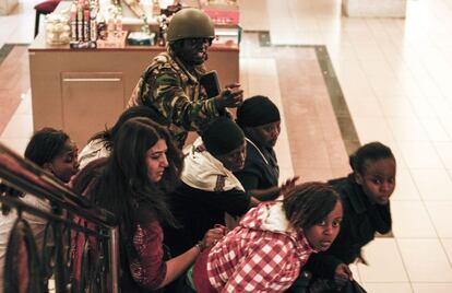 Un soldado dirige la evacuaci&oacute;n de las personas que se hallaban en el centro comercial Westgate de Nairobi cuando se ha producido el ataque.