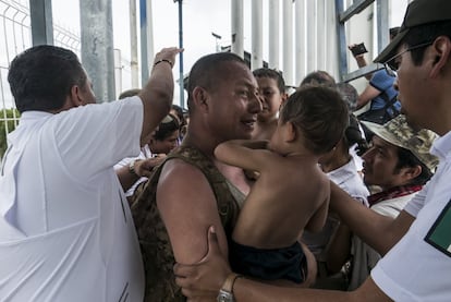 Um homem carrega seu filho para evitar que se desidrate e desmaie no meio da aglomeração na ponte fronteiriça Rodolfo Robles.