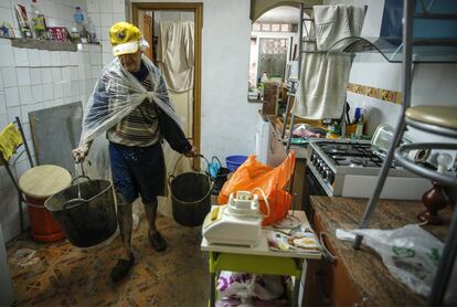 Una persona limpia su vivienda tras las lluvias de las últimas horas.