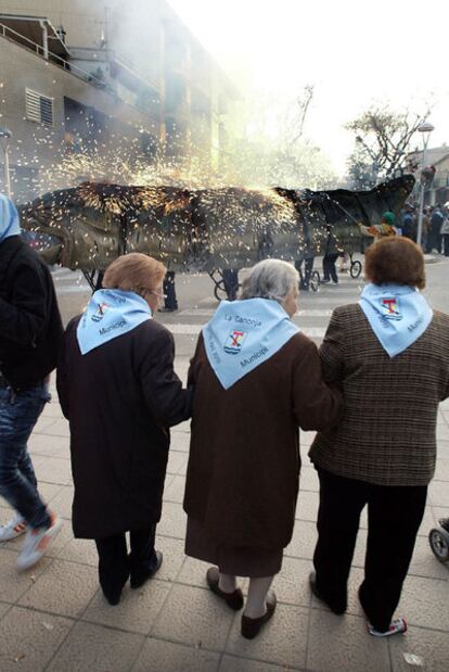 Tres mujeres, con sus pañuelos con el escudo y los colores de La Canonja, contemplando el <i>correfoc</i>.