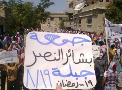 Un opositor al régimen del presidente sirio Bachar el Asad participa en una protesta levantando un cartel donde se puede leer: "El viernes del principio de la victoria"