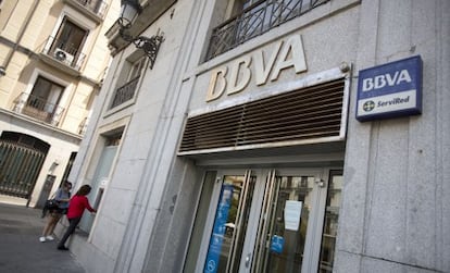 Dos clientes sacan dinero en un cajero de BBVA.