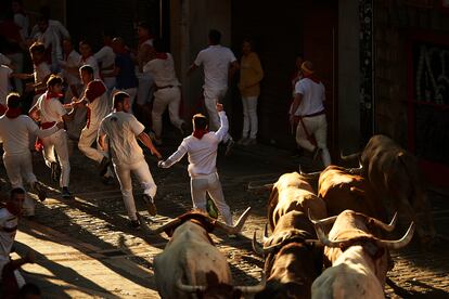 Varios mozos corren delante de toros de Núñez del Cuvillo, durante el primer encierro de las fiestas de San Fermín.
