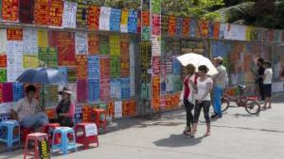 Pared cubierta con anuncios publicados por empresarios con ofertas de trabajo, en Sanya, en la provincia de Hainan (China). EFE/Archivo