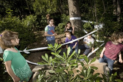 Los niños que han encontrado el rosetón enterrado juegan en la zona tras ser retirada la pieza para su estudio.