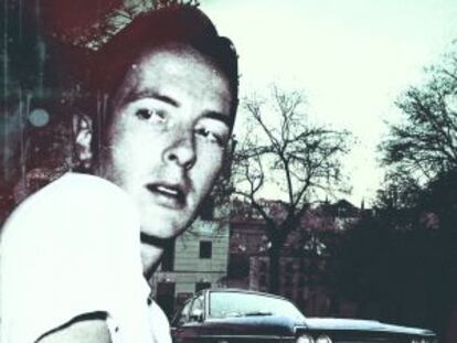 Clash frontman Joe Strummer with a Dodge in the background.