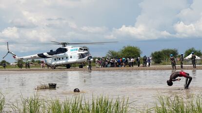 Unos niños se bañan en una zona inundada cercana al lugar de aterrizaje de un avión del Programa Mundial de Alimentos cargado de ayuda humanitaria en Pibor, Sudán del Sur, el 6 de octubre de 2020.