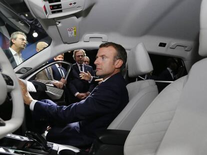 El presidente francés, Emmanuel Macron, examina el interior de un vehículo, durante la feria del automóvil, este miércoles en París.