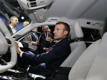 El presidente francés, Emmanuel Macron, examina el interior de un vehículo, durante la feria del automóvil, este miércoles en París.