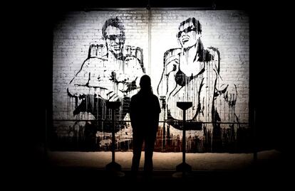 Un visitante observa un mural de un graffiti de Banksy.