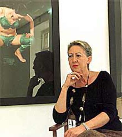 Carmen de la Calle, posa en su galería ante obras Mira Bernabeu.