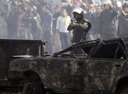 Un policía antidisturbios apunta con su fusil de balas de goma durante una manifestación cercana al ministerio del Interior.