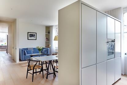 El salón-comedor está separado de la cocina por un módulo autónomo que contiene la nevera y el horno. Al no tocar las paredes ni el techo, contribuye a crear un espacio único fluido.
