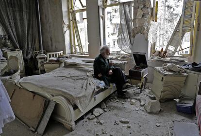 Mohammed Mohiedin Anis, de 70 años, fuma en pipa sentado en su dormitorio rodeado de escombro mientras escucha música de un viejo tocadiscos en Alepo (Siria), el 9 de marzo de 2017.