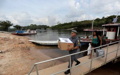 Policial leva a urna eletrônica para a comunidade Nossa Senhora de Fatima community, na margem do Rio Negro, no Amazonas, em 6 de outubro.