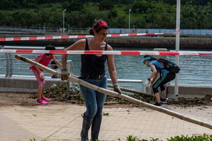 Carola Ross, de Chile, residente en Tseung Kwan O, y otros voluntarios recogen escombros en el paseo marítimo del distrito de Tseung Kwan O, en Hong Kong (China).