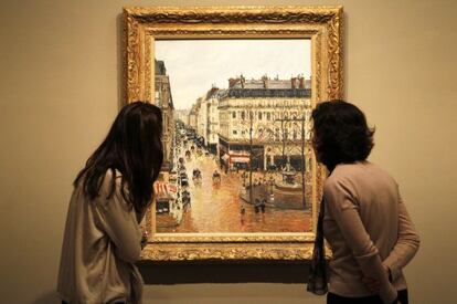 Dos visitantes contemplan el cuadro 'Rue Saint-Honoré por la tarde. Efecto de lluvia', de Camille Pissarro, en el Museo Thyssen.