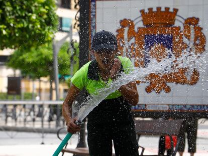 Una operaria del Ayuntamiento de Écija (Sevilla) se refresca con una manguera el 28 de abril de 2023.