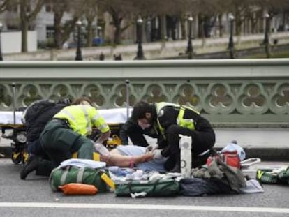 Miembros de los equipos de emergencia atienden a una de las v&iacute;ctimas del atentado en Londres.