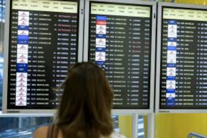 Una mujer observa los paneles de información de los vuelos en el aeropuerto de Barajas. EFE/Archivo