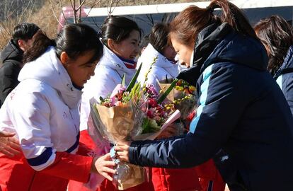 Jogadora sul-coreana entrega flores para a colega norte-coreana, nesta quinta-feira.