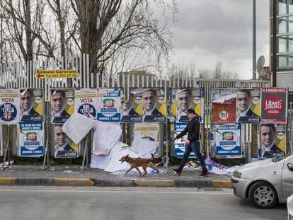 Un vecino de Pomigliano D'Arco pasea delante de los carteles electorales.