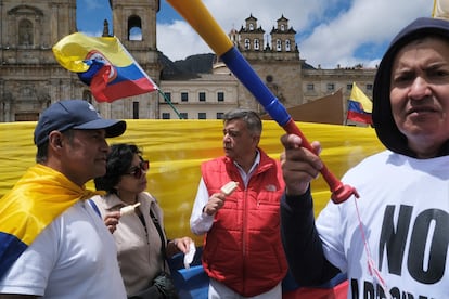 Varios manifestantes comen un helado mientras esperan el inicio de las intervenciones de algunos senadores al finalizar la marcha en en la Plaza de Bolívar de Bogotá.