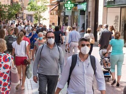 Transeúntes se protegen con mascarillas por las calles