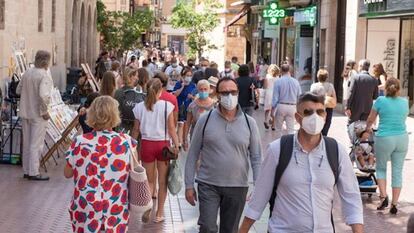 Transeúntes se protegen con mascarillas por las calles