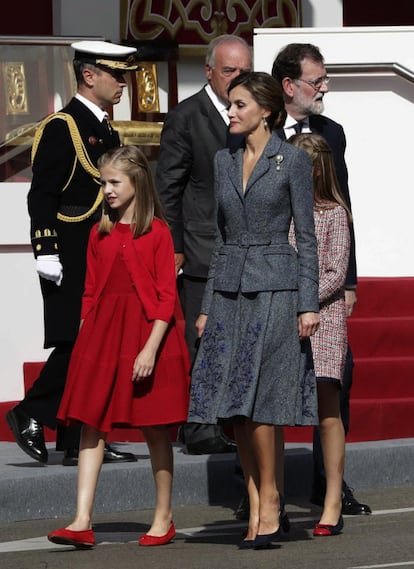La reina Letizia, junto a la princesa Leonor y la infanta Sofía, y el presidente del Gobierno, Mariano Rajoy (dcha.), durante el desfile del Día de la Fiesta Nacional, el 12 de octubre de 2017. 
