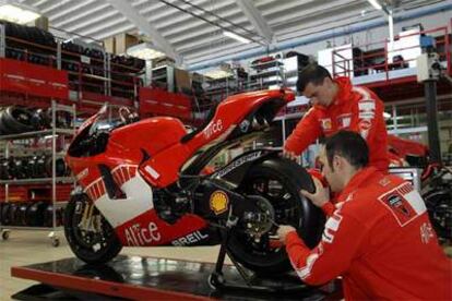 Dos operarios de Ducati ajustan una moto.