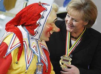 Angela Merkel, junto a una persona disfrazada, en las fiestas de carnaval en Berlín.