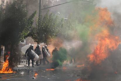 Un grupo de policías antidisturbios pasan junto a un incendio durante la protesta frente al tribunal donde se celebra el juicio de los líderes y miembros del partido de extrema derecha Aurora Dorada en Atenas, Grecia. el 7 de octubre de 2020. 