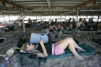 Algunos asistentes al festival de Benicàssim descansaban ayer debajo de un ecenario.