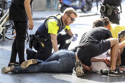 Atentado en La Rambla de Barcelona. Un agente de la Guardia Urbana atiende a una mujer herida.